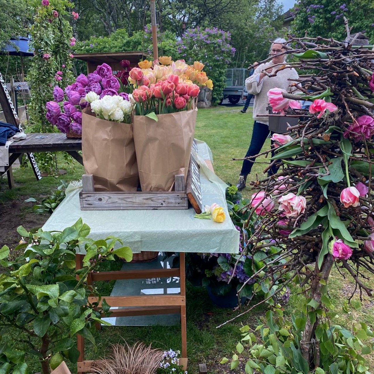 Pop-up-butik i en trädgård med buketter i papperspåsar